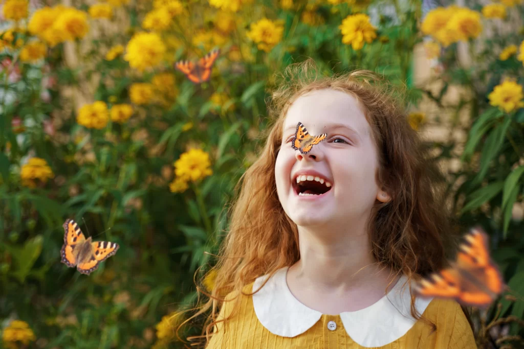 Lachend meisje met een vlinder op haar neus