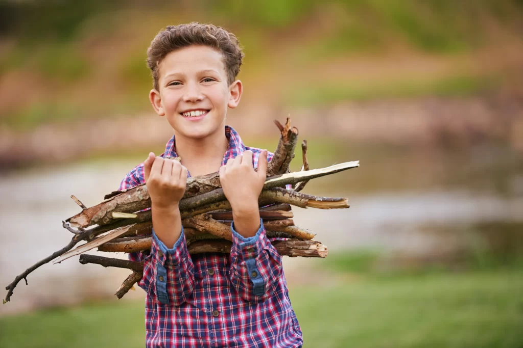 Jongen met een arm vol brandhout